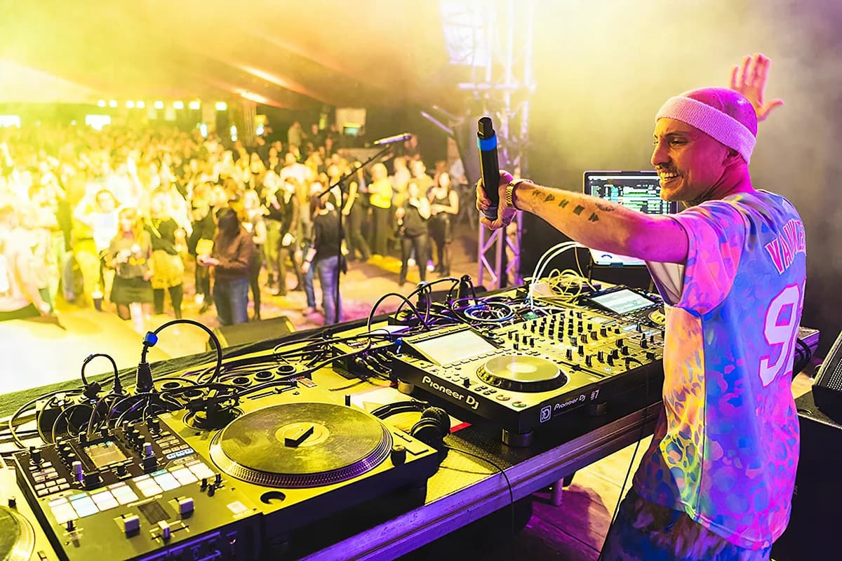 DJ am Pult über der tanzenden Menge